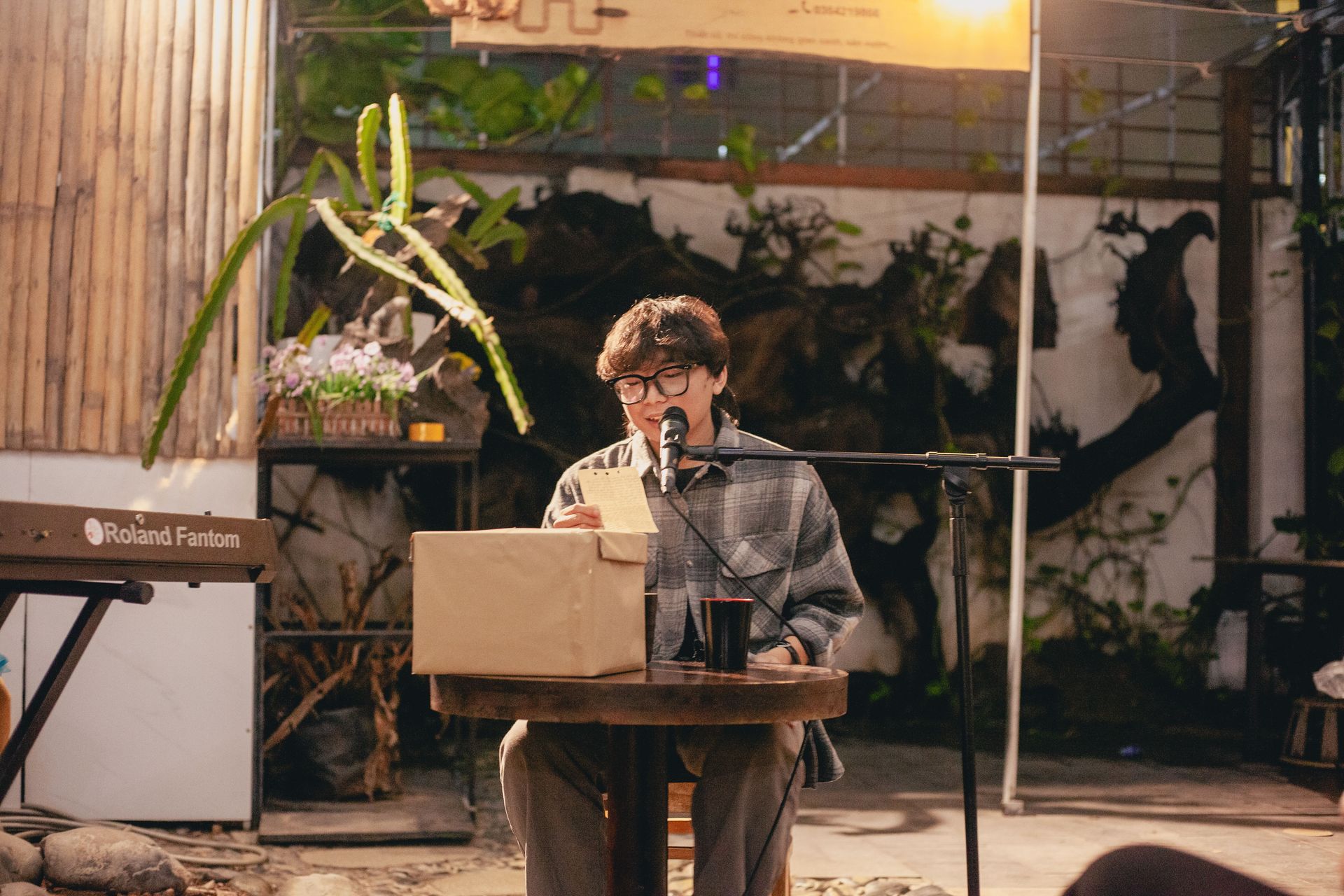 Young artist performing a poetry reading outdoors with a microphone.